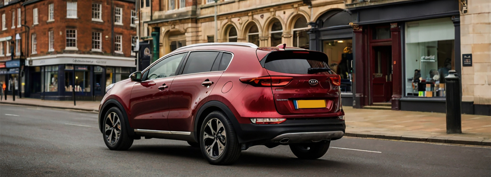 A Red Compact Kia Sportage SUV driving on a city street